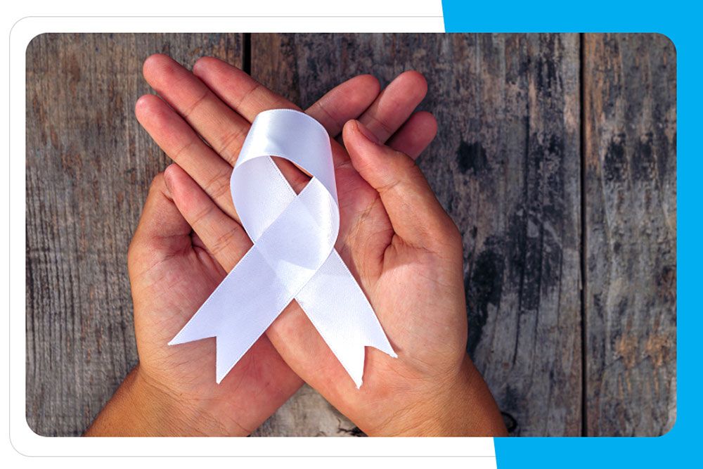 Zdjęcie dłoni, na których złożona jest biała wstążka.