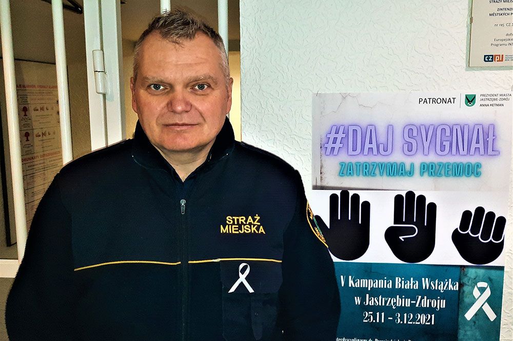 Strażnik miejski z przypiętą do munduru białą wstążką.