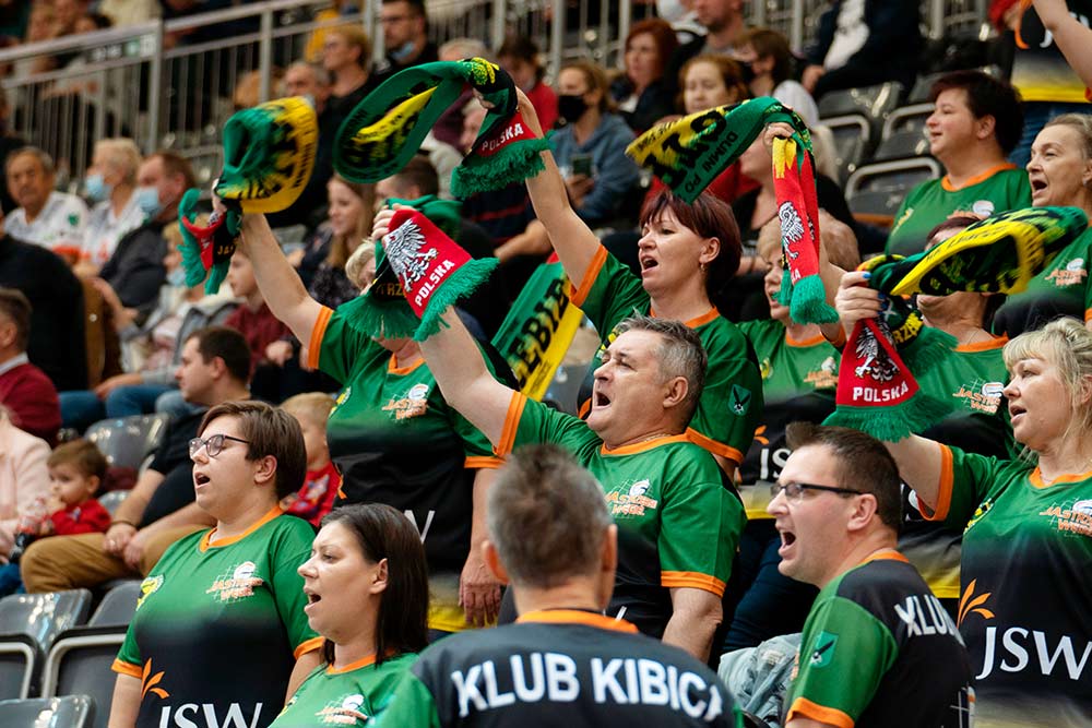 Zdjęcie przedstawia kibiców Jastrzębskiego Węgla na trybunach hali.