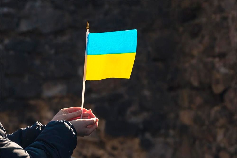 Trzymana w dłoni chorągiewkę w barwach flagi Ukrainy.
