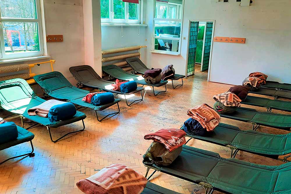 Widok na salę z łóżkami polowymi.