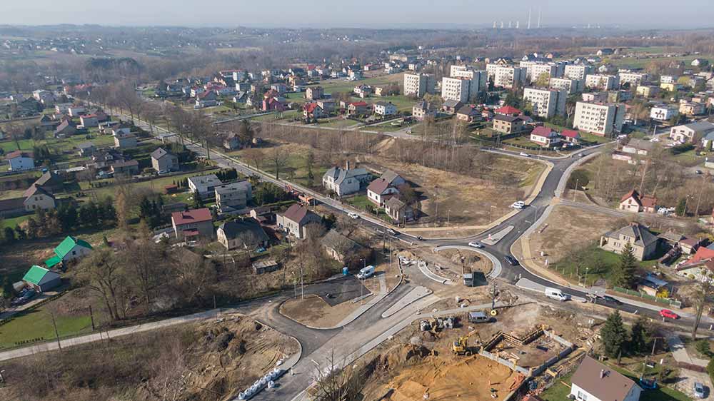 Widok z lotu ptaka na budowę. W oddali widać osiedle.