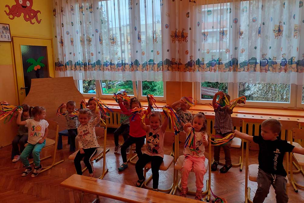 Dzieci kibicują kolegom startującym w konkurencjach.