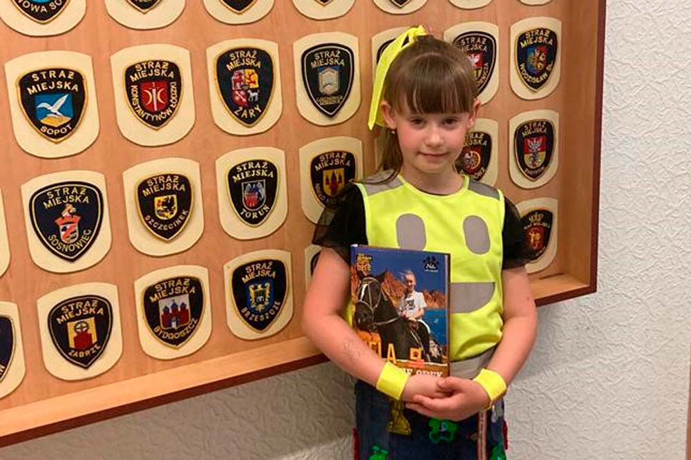 Marysia pozuje do zdjęcia na tle kolekcji naszywek na mundury.