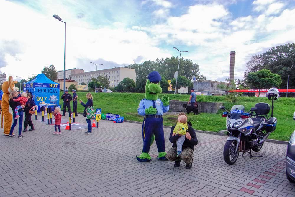 Maskotka SMokuś bawi się z dzieckiem.