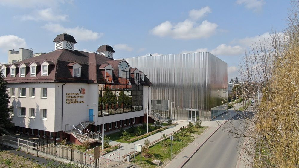 Zajęcie przedstawia szkołę muzyczną i salę koncertową. 