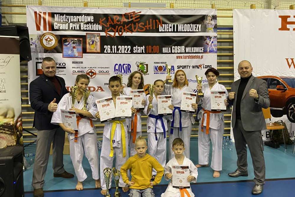 Zawodnicy i trenerzy pozują do pamiątkowego zdjęcia.