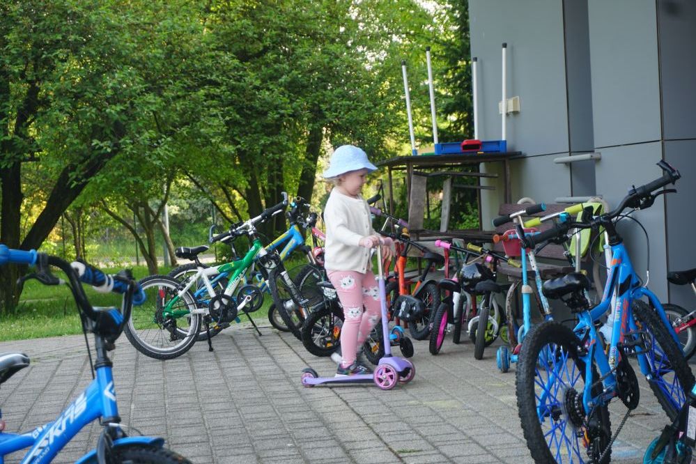 Na zdjęciu dziewczynka dojeżdzjąca do przedszkola na hulajnodze.