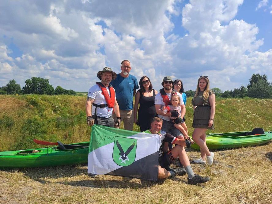Uczestnicy z flagą miasta.