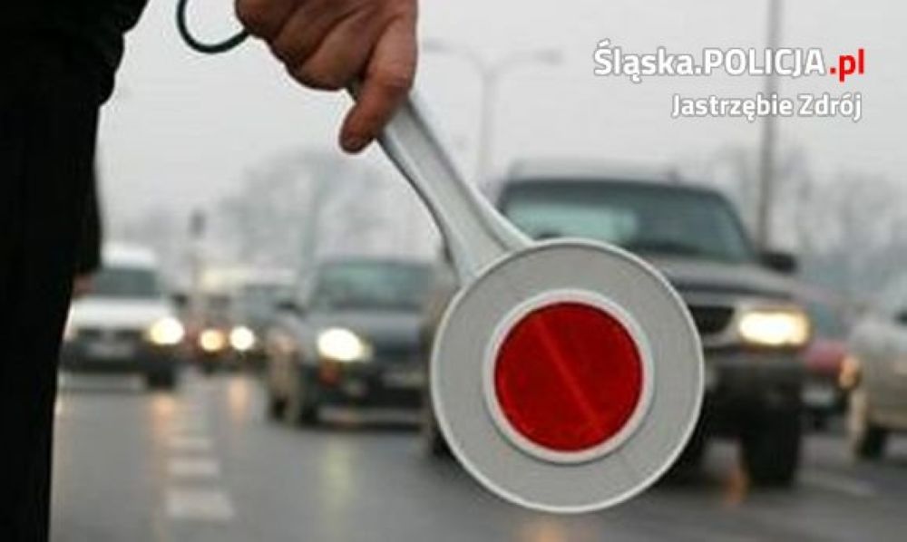 Zdjęcie przedstawia policjanta z lizakiem, przed kontrolą.