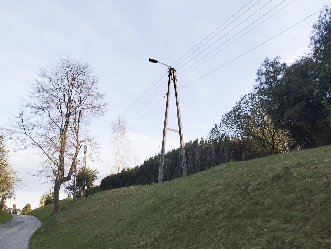 Słup oświetleniowy na skarpie, linie energetyczne