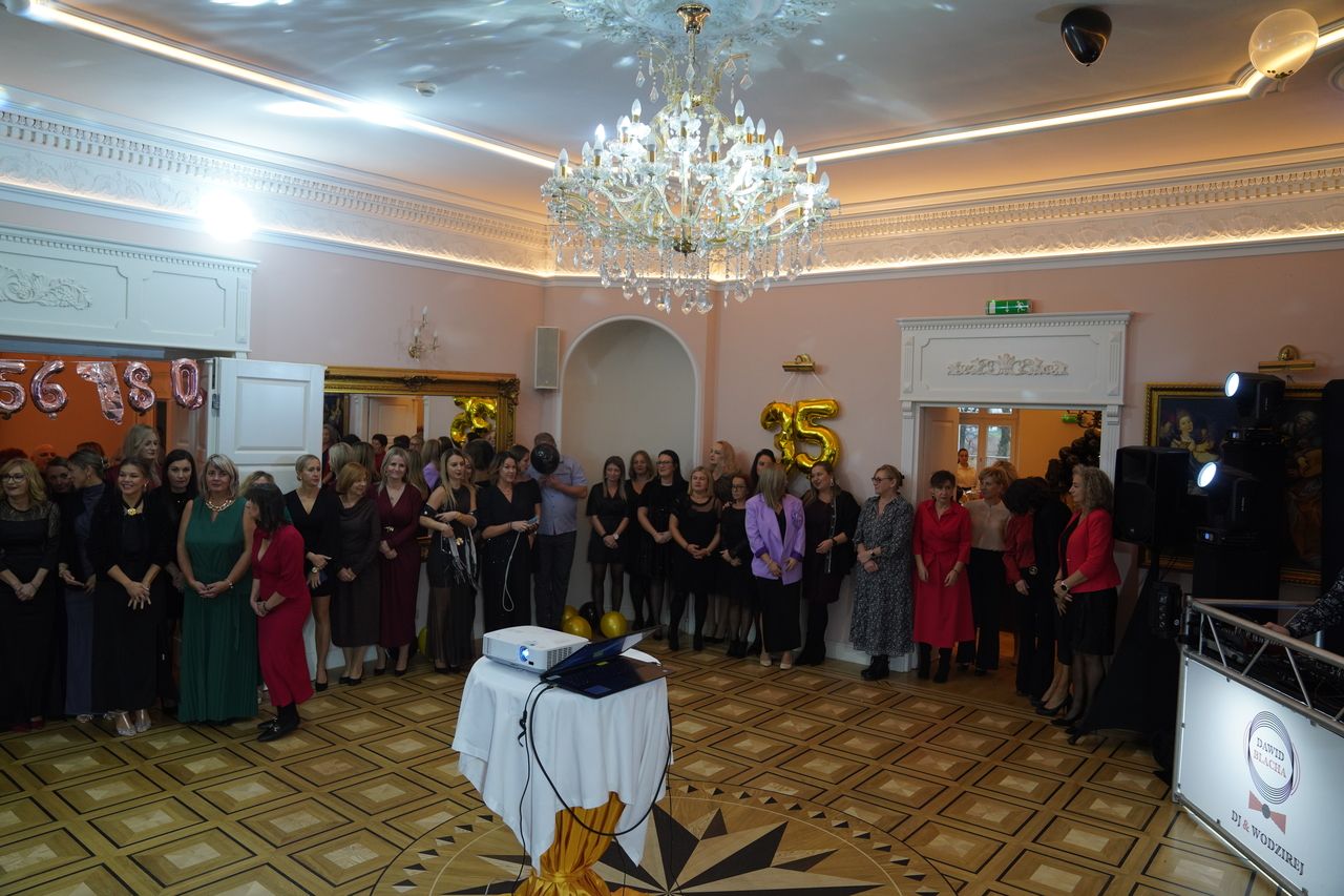 Pracownicy Ośrodka Pomocy Społecznej stojacy na wejściu do sali, stojący przed projektorem