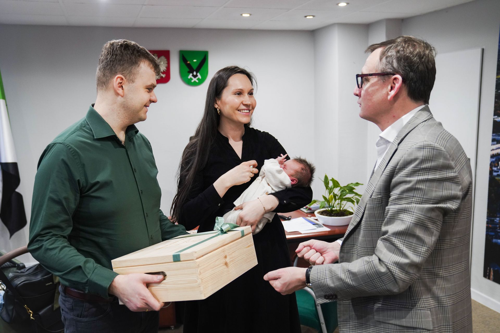 Prezydent Michał Urgoł wręcza rodzicom Adasia upominek