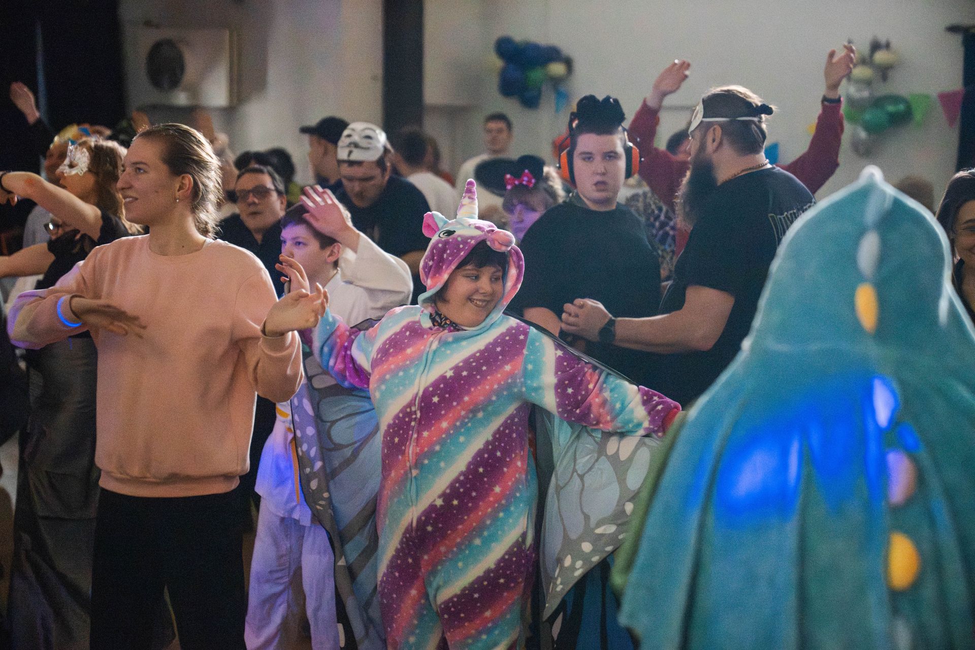 wspólny układ taneczny na czele postać w różnokolorowym stroju