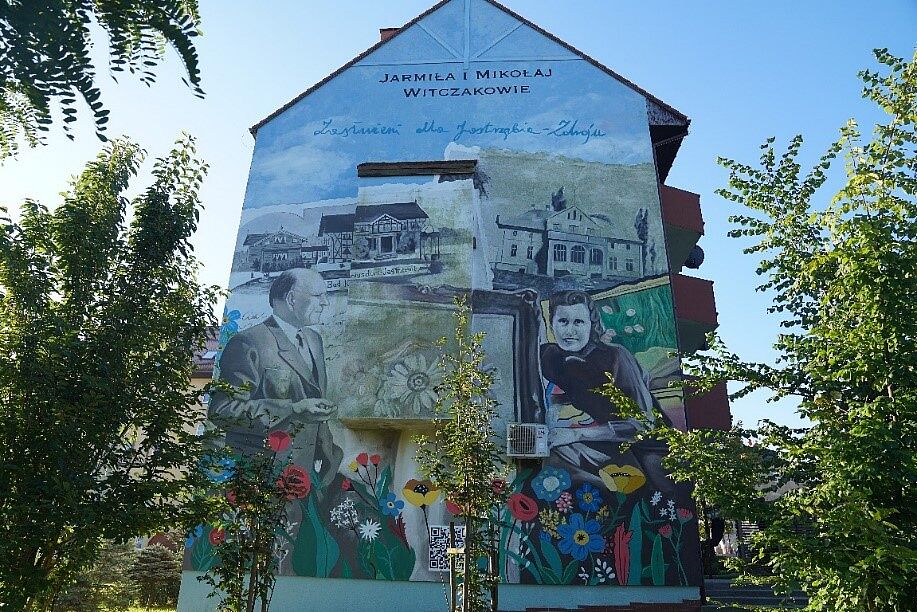Mural na ścianie budynku przedstawia profil Mikołaja i Jarmiły Witczaków na tle uzdrowiskowej zabudowy Jastrzębia-Zdroju i kolorowych kwiatów. U góry widnieje napis „JARMIŁA I MIKOŁAJ WITCZAKOWIE Zasłużeni dla Jastrzębia-Zdroju”