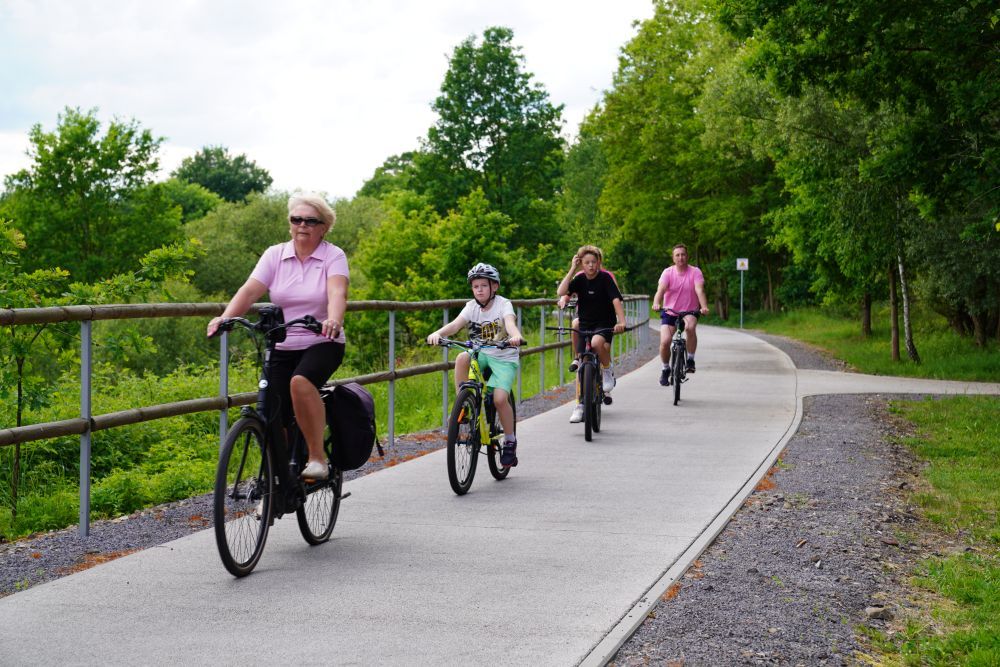 Zdjęcie przedstawia ludzi jadących na rowerze