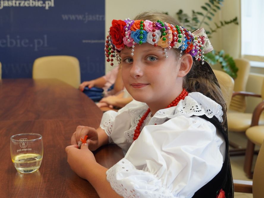 Zdjęcie przedstawia dziewczynkę w stroju ludowym.