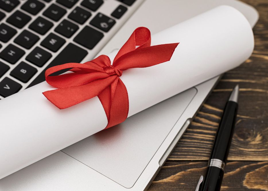 Zdjęcie przedstawia zwiniętą kartkę papieru na notebooku